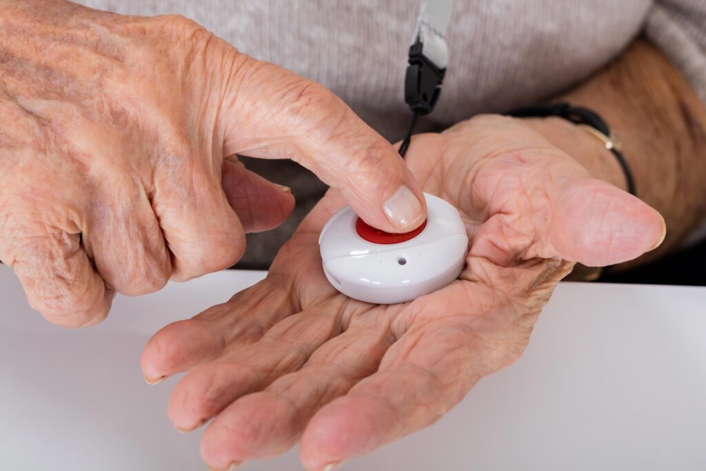 Old person holding medical pendent in hand